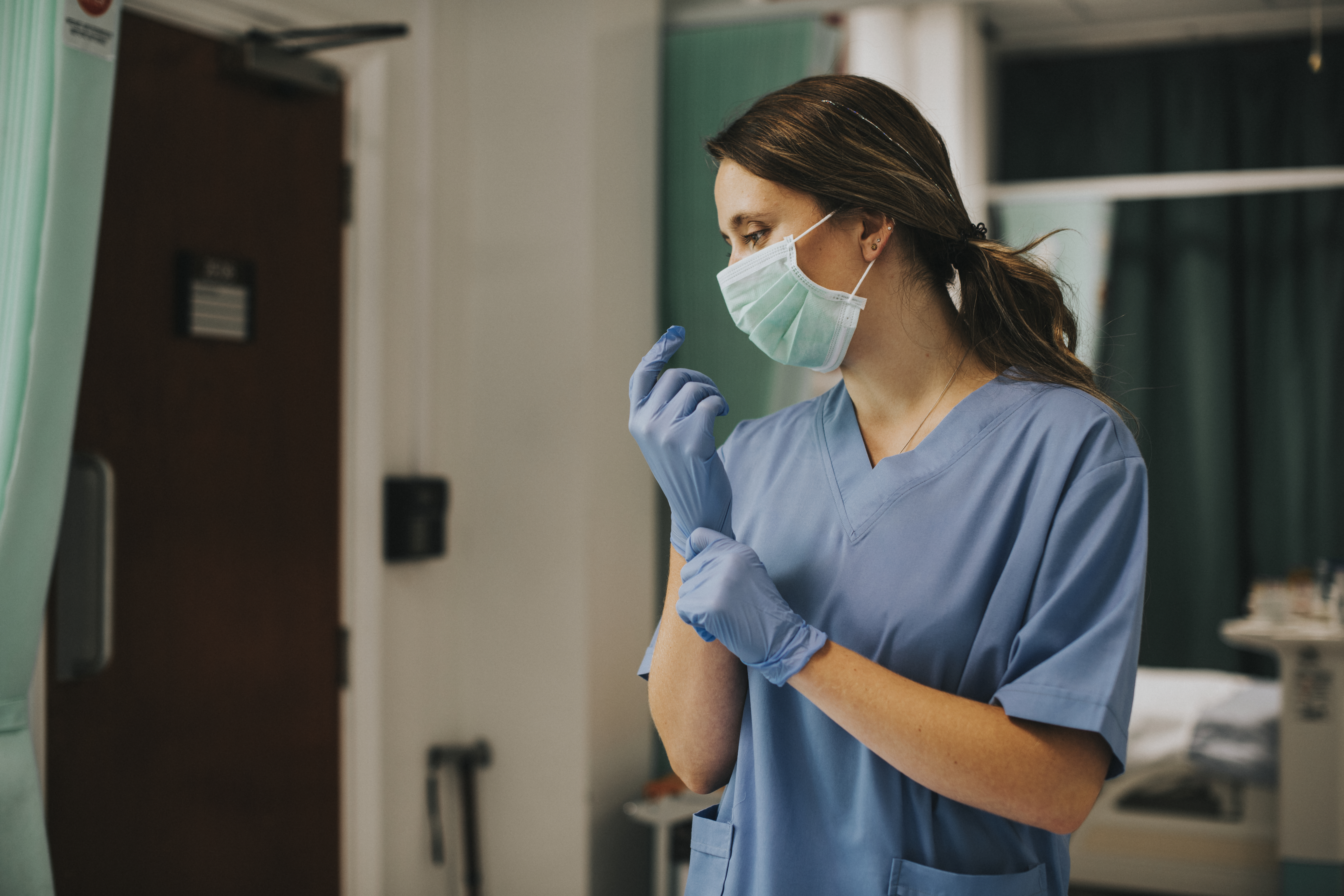 Enfermera de TuAuraSalud preparándose con guantes y tapabocas